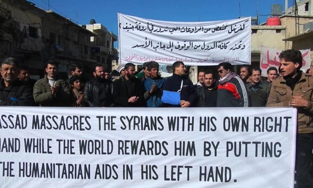 Syria: Raed Fares At Kafranbel Friday Protest – “Assad Massacres Civilians, World Rewards Him With Aid”