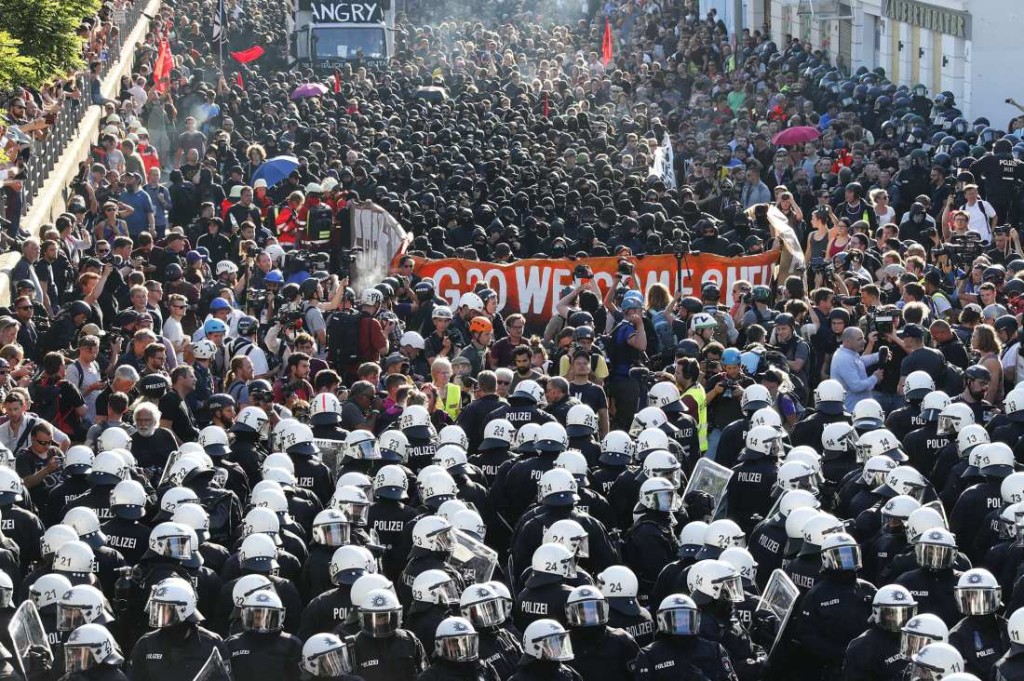 German riot police stand in front of protesters during the demonstrations during the G20 summit in Hamburg