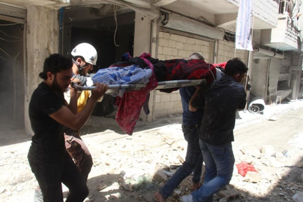 Rescuers carry a victim slain by pro-Assad bombardment of Idlib Province, Syria, May 27, 2019