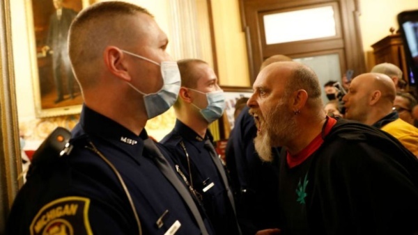 A protester against Coronavirus orders yells at security personnel in the Michigan State Capitol, April 30, 2020