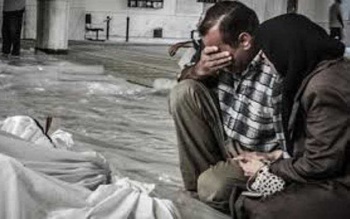 A couple mourn a victim of the Assad regime's sarin attacks near Damascus, August 21, 2013