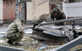 Police officers inspect the remnants of a Russian missile fired on Kyiv
