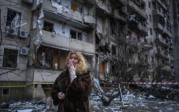 Natali Sevriukova stands outside her apartment block, damaged by Russian shelling, Kyiv, Ukraine, January 25, 2022 (Emilio Morenatti/AP