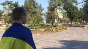 A man in Mariupol in southern Ukraine defies Russian occupiers by wearing the Ukrainian flag on the site of the demolished Drama Theater, July 18, 2022