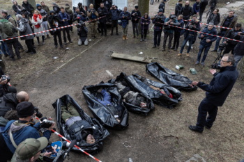 Journalists surrounding victims of atrocities in Bucha, a suburb of Kyiv occupied by Russian forces from March 4 to 31, 2022 (Marco Djurica/Reuters)