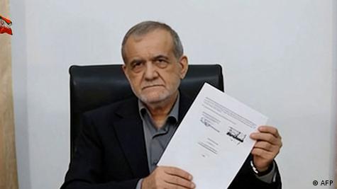 Iranian President Masoud Pezeshkian holds up a copy of the Memorandum of Understanding ending the US War on Iran, June 18, 2026